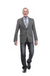 © ASDF - full length picture of a mid aged business man walking towards the camera and smiling.