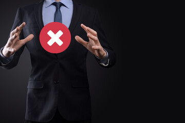 Wall Mural - Hand holds icon,cancellation symbol,cancel icon.Cross mark flat red icon.round X mark.cancel button.Wrong.cross mark rejection.Declined.On dark background.Banner.Copy space.Place for text.