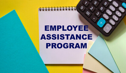 employee assistance program business text concept written on notepad and yellow background with calc