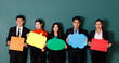 © Bangkok Click Studio - Portrait studio shot group of Asian professional male female teacher or college students in formal suit outfit standing smiling look at camera holding conversation sign on green chalkboard background