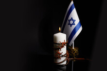 Barbed Wire On Burning Candle And Israel Flag On Black Background With Space For Text. Holocaust Memory Day