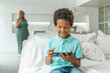 © millaf - Cute child boy with smartphone playing game online at home