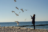 Fototapeta Fototapety z morzem do Twojej sypialni - Dziewczyna i ptaki na morskiej plaży