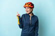 © luismolinero - Young cyclist woman isolated on blue background intending to realizes the solution while lifting a finger up
