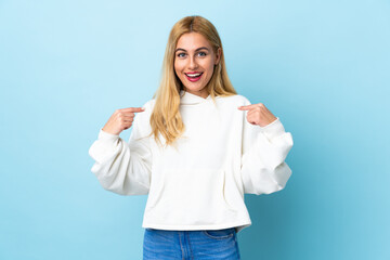 Wall Mural - Young Uruguayan blonde woman over isolated blue background with surprise facial expression