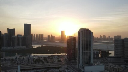 Wall Mural - Sunset in Abu Dhabi, aerial view on Al Reem island surrounded by modern skyscrapers between the mangroves in the sea