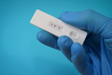 Closeup shot of a hand holding a positive antigen test