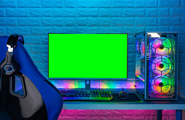Wall Mural - gaming chair and colorful bright rgb pc with keyboard mouse monitor green screen copy space in front of LED light brick stone wall. Computer playing hardware games background