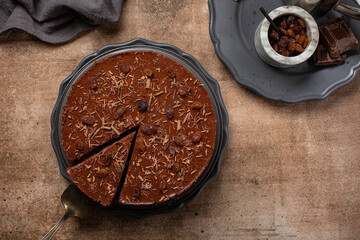 Wall Mural - Chocolate no bake mousse cake with raisins on brown background. Homemade. Directly above.