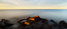 Breakwater Against Colorful Sunset Sky. Stunning Seascape. Golden Sunset Light Through The Blue Clouds. Long Exposure. Baltic Sea, Riga Bay, Latvia