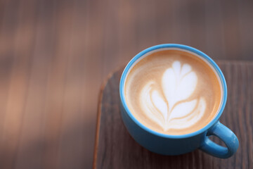 Canvas Print - Ceramic cup of aromatic coffee with foam on wooden table. Space for text