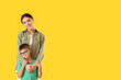 © Pixel-Shot - Little boy with his older sister on yellow background
