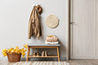 © Pixel-Shot - Jacket and hat hanging on light wall and basket with autumn leaves in interior of stylish hallway