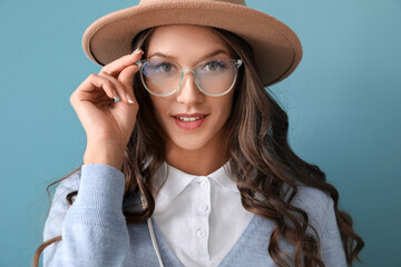 Wall Mural - Portrait of young woman wearing stylish eyeglasses on blue background