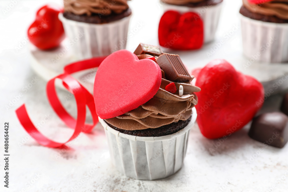 Tasty chocolate cupcakes for Valentine's Day on light background