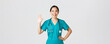 Covid-19, healthcare workers and preventing virus concept. Friendly-looking smiling asian female doctor, physician in scrubs waving hand to say hi, hello, greeting patient, nice to see you