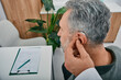 © Peakstock - Audiologist fits a hearing aid on deafness mature man ear while visit a hearing clinic. Hearing solutions for older