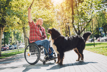 Wall Mural - Happy young man with a physical disability who uses wheelchair with his dog.