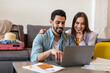 © Prostock-studio - Young couple using laptop planning vacation and booking tickets online, preparing for vacation at home