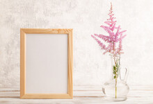 Wooden Frame With Pink Astilbe Flowers In Glass Vase On Gray Concrete Background. Side View, Copy Space.