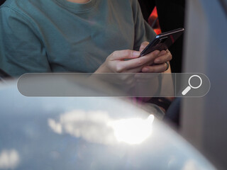 Wall Mural - young woman using a smart phone. with the search technology search console on the car