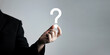 © Midnight Studio - businessman holding question mark. concept of Question mark and FAQs, Ask quiestion online, FAQ concept, what how and why, search information on internet.