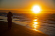 Silhouette of a young woman at the beach enjoying sunset