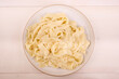 Homemade fettuccine alfredo in a plate with grated cheese, top view on a light background
