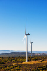 Wall Mural - wind turbines on a beautiful blue sky in a mountain wind farm in sardinia. renewable energy concept,