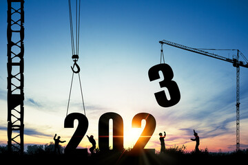 Wall Mural - silhouette of construction worker with crane and cloudy sky for preparation of welcome 2023 new year