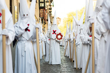 The Extraordinary Christian Procession Of The Holy Week In Granada, Andalucia, Spain. Unrecognizable People Dressed As Nazarenes Spreading Catholic Faith In Public.