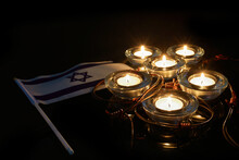 Burning Candle And Flag Of Israel On Black Background. Holocaust Memory Day