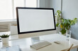 © Seventyfour - Minimal background image of office workplace with blank white computer screen on desk, copy space