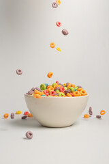 Colorful cereal box for morning breakfast. Corn flakes falling to the white bowl. Motion.