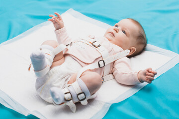 a baby wearing a harness that corrects hip dysplasia