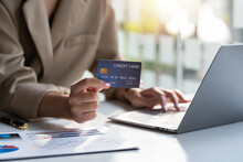Businesswoman Hand Holding Credit Card And Using Laptop. Close Up Of Female Hands Credit Card Payment.  Online Shopping Concept.