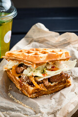 Canvas Print - Waffle sandwich with meat and vegetables on wooden table background