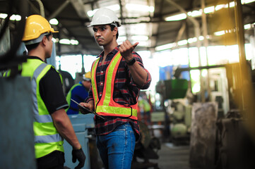 Wall Mural - Dark tall and handsome Asian Professional engineering man are training and coaching the technician Machine operator control and checking operating in factory. safety first concept.