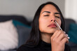 Detail portrait of woman performing an automatic COVID-19 test at home with Antigen kit. Introduction of nasal swab test for possible Coronavirus infection. Online medical and health-related services.
