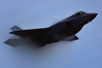 Very unusual close view of a F-35C Lightning II  at very high speed, with condensation cone (“singularity”) around the plane