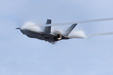 Wall Mural - Very unusual close view of a F-35C  in a high G maneuver , with condensation clouds over the wings and afterburner on