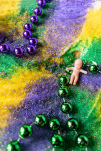 Closeup King Cake With Mardi Gras Beads And Baby On Vintage Tray