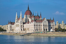 Budapest, Hungary. The Hungarian Parliament Building On The Bank Of The Danube, And Fragment Of The Building Of Ethnographic Museum, Former Royal Palace Of Justice.