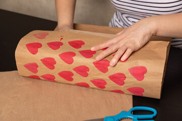 heart shaped potato stamp on craft paper. The process of decorating a gift for Valentine's Day. Getting ready for the celebration on February 14th.