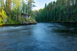 Kitka river landscape with a wooden cottage on the riverbank by Pieni Karhunkierros hiking trail in Oulanka national park, Northern Finland, Europe.