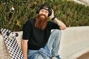 Sticker - Young irish skater man smiling happy using headphones at the park