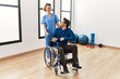 © Krakenimages.com - Young physiotherapist woman and disabled man smiling happy at the clinic.