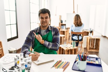 Poster - Young artist man at art studio pointing aside worried and nervous with forefinger, concerned and surprised expression