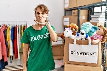 Poster - Beautiful caucasian woman wearing volunteer t shirt at donations stand cutting throat with hand as knife, threaten aggression with furious violence