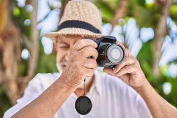 Canvas Print - Senior man smiling confident wearing summer hat using camera at park